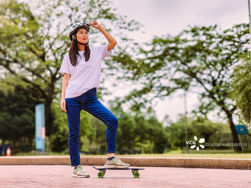 在城市里玩滑板的女性滑板运动员图片素材