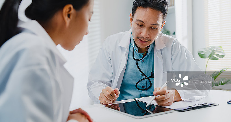 年长的亚洲男人和年轻女医生在诊所会议室讨论医疗报告图片素材