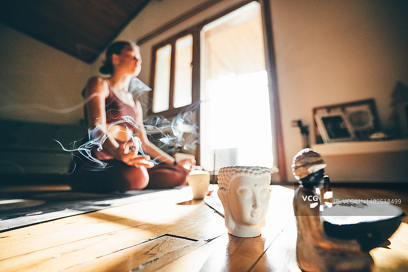 年轻女人在家里做瑜伽和冥想图片素材