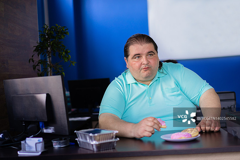 体型较大的男人吃甜甜圈图片素材