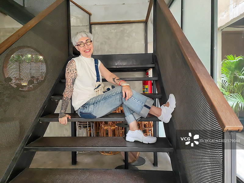 年长的女人坐在楼梯上微笑图片素材