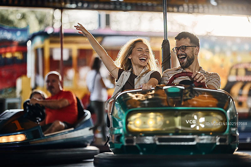 快乐情侣在游乐园玩碰碰车图片素材