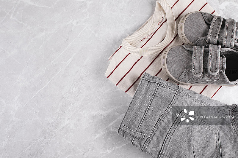 浅色大理石背景上的男婴服装套装，夏季时尚童装，扁平风格俯视图图片素材