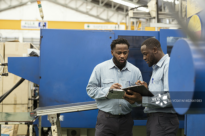 塑料注塑成型行业的根本原因评估与分析：生产控制主管和机器操作员正在生产线上调查机器停机事件并防止再次发生图片素材