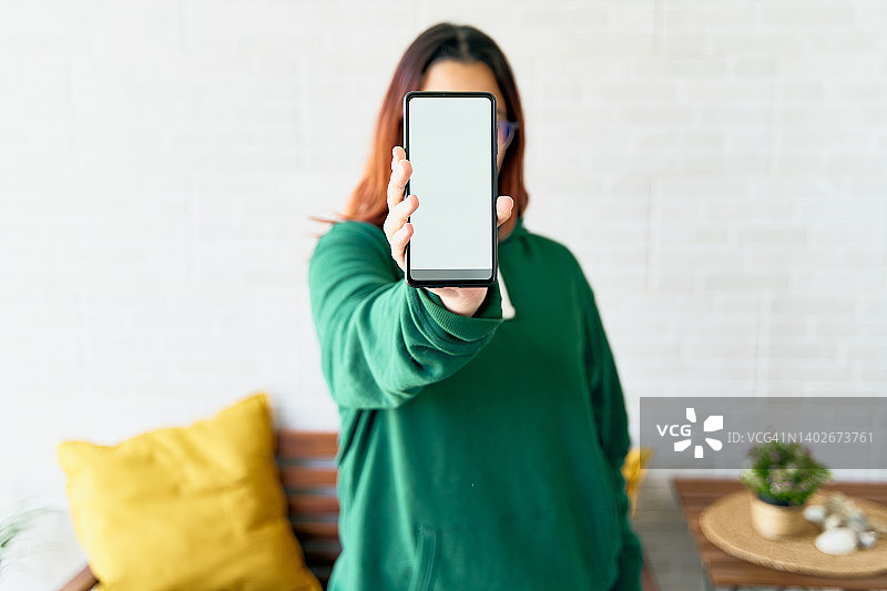 混血青少年展示带有空白白色屏幕的智能手机图片素材