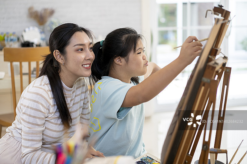 母亲教患有唐氏综合征的女儿学习艺术图片素材