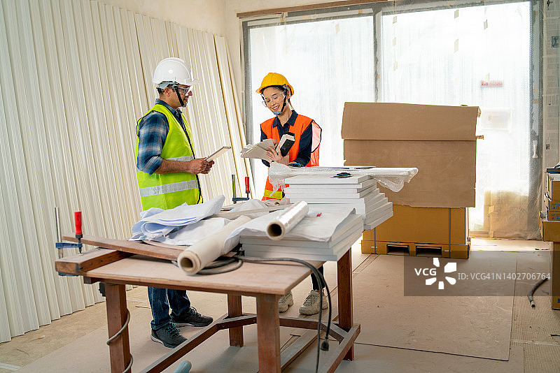 亚洲女工与印度工程师或技术员讨论建筑工地房屋的内部结构图片素材