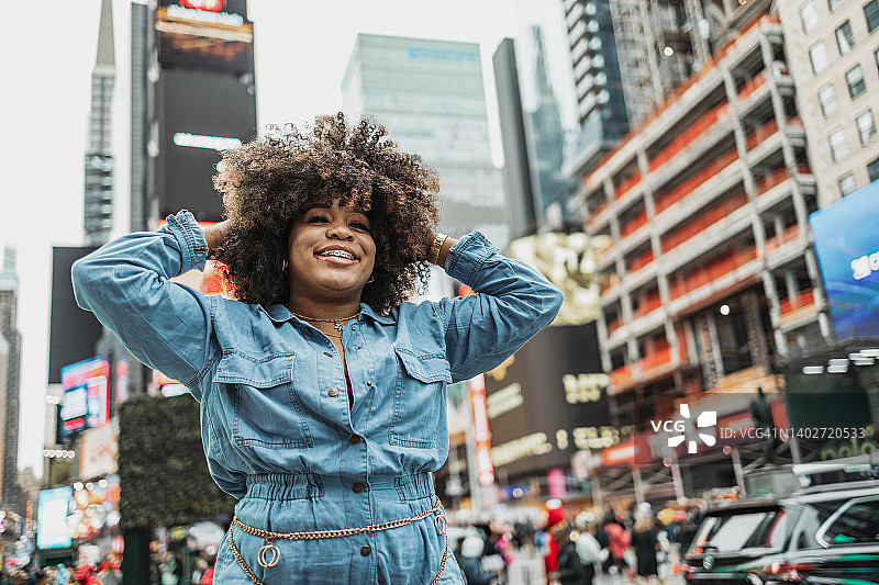 在时代广场微笑的漂亮非裔美国年轻女人图片素材