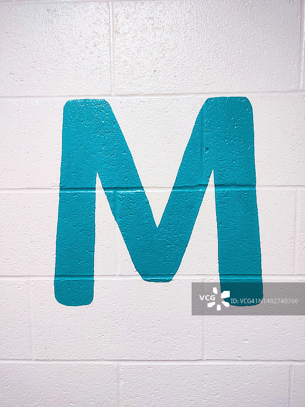 白色砖墙上的字母M图片素材
