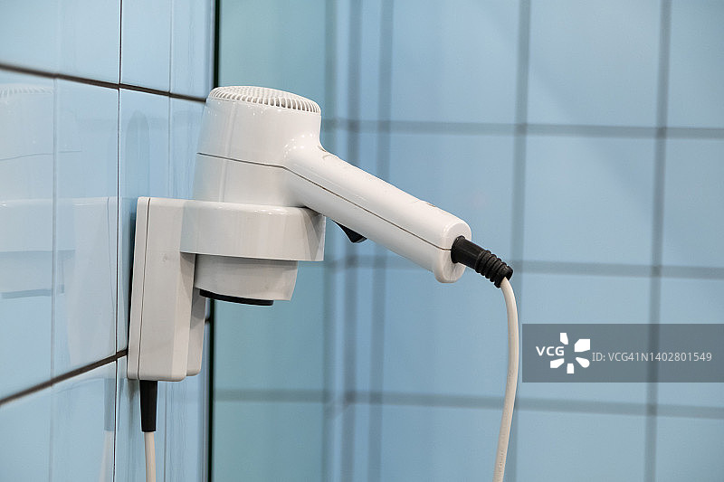 游泳池、学校或酒店更衣室里用于吹干头发的吹风机。公共洗手间或淋浴室。旅馆或宿舍的浴室内部。浴室、家里、医院病房或购物中心的吹风机图片素材