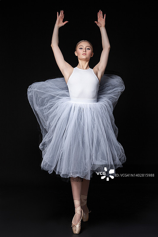 举起手臂跳舞的年轻芭蕾舞女演员图片素材