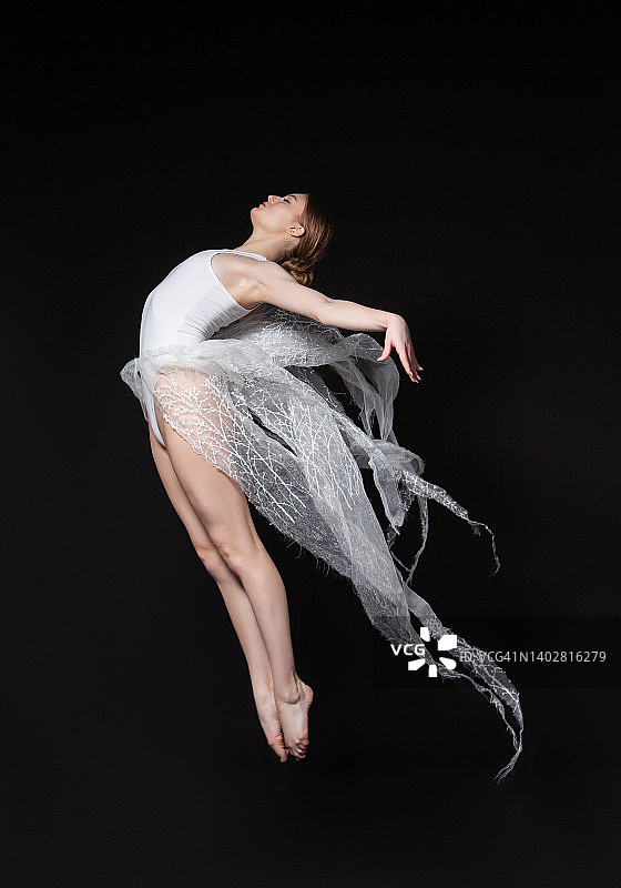 张开双臂跳跃的赤脚女舞者图片素材