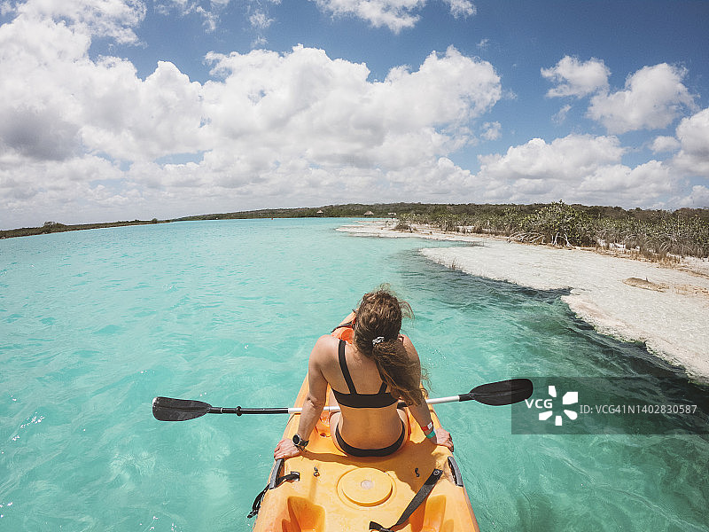 女子在巴卡拉尔湖上划皮划艇图片素材