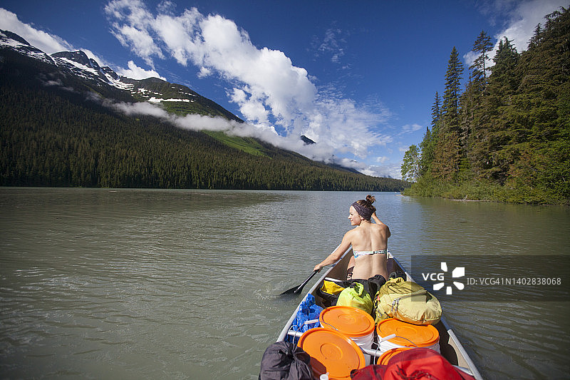 划独木舟穿越兰齐湖的年轻女人图片素材