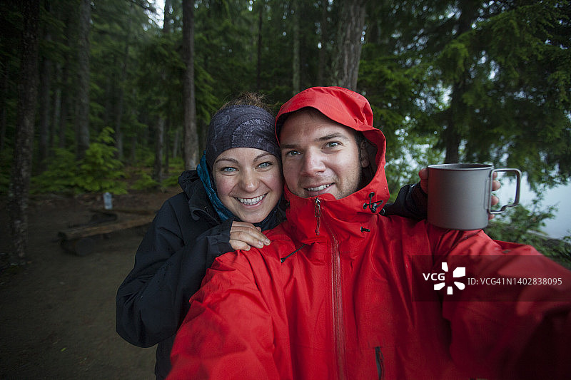 在博伦湖省立公园露营时，一对情侣在雨天自拍图片素材