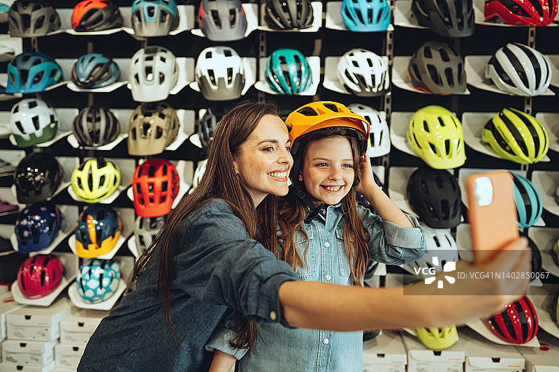 母女在自行车店戴头盔自拍图片素材