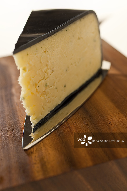 裹在蜡纸里的蒜香草药切达奶酪特写图片素材