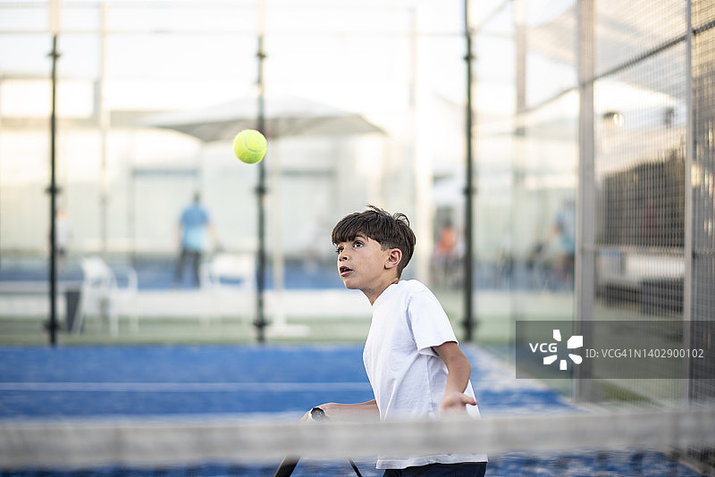 小男孩在球场上打板式网球，体育课上击球图片素材