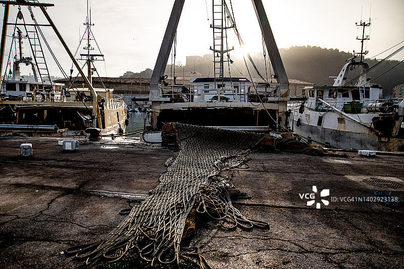 意大利港口渔船上的工业渔网在清晨捕鱼后晾干图片素材