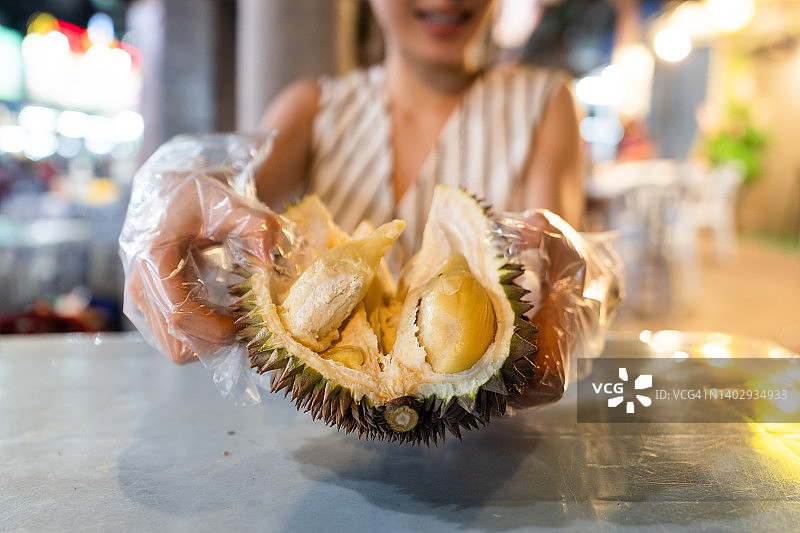 在阿罗街夜市吃新鲜榴莲的亚洲女性图片素材