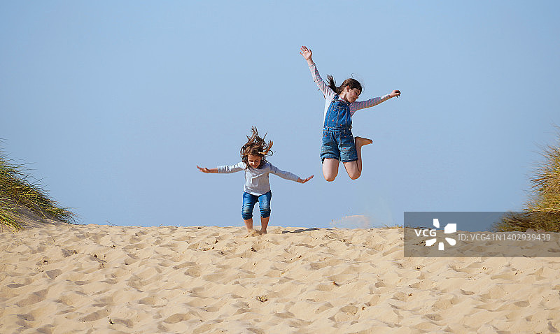 英国超级假期，女孩在海滩上指向空中图片素材