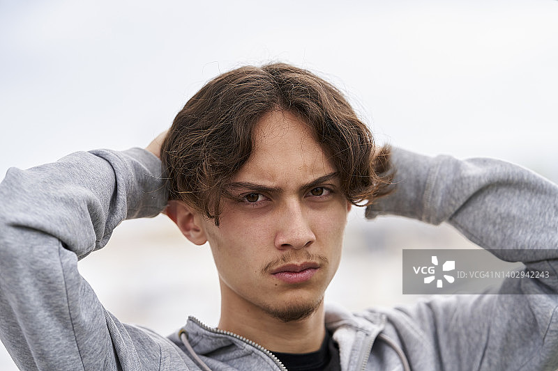 忧郁少年双手抱头肖像图片素材