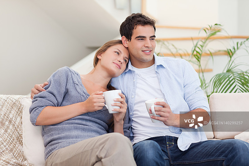 情侣一边喝茶一边看电视图片素材