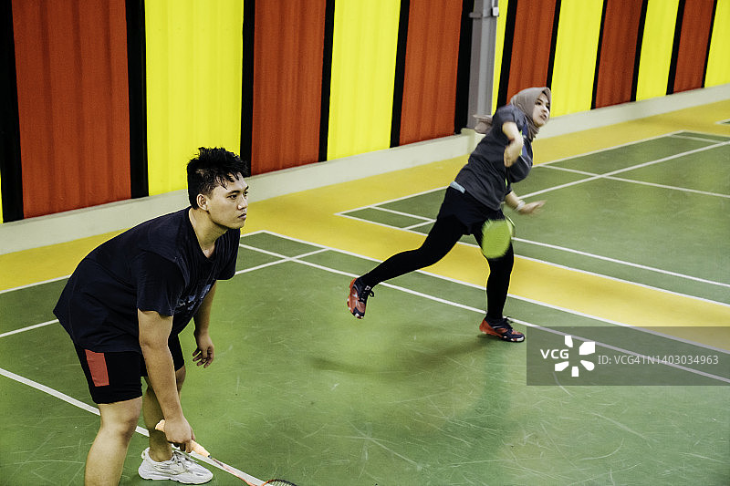 两对情侣在室内球场打羽毛球图片素材