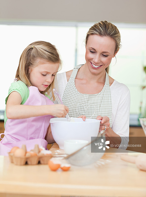 微笑的母亲和女儿准备饼干面团图片素材