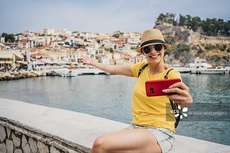 年轻女人在海边录制视频博客。图片素材