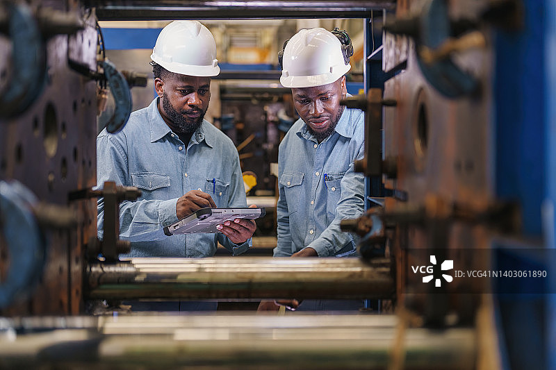 工程师向新工程师讲解机器功能。图片素材