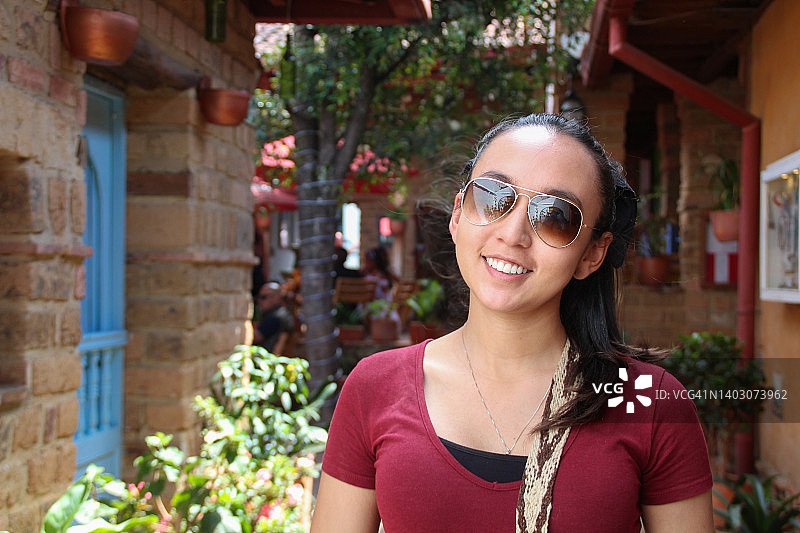 年轻女人戴着太阳镜工作和旅行时微笑图片素材