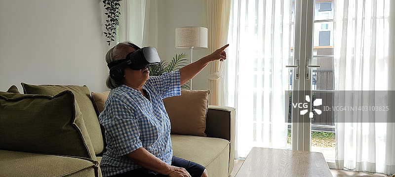 使用VR虚拟现实模拟器的年长女性图片素材