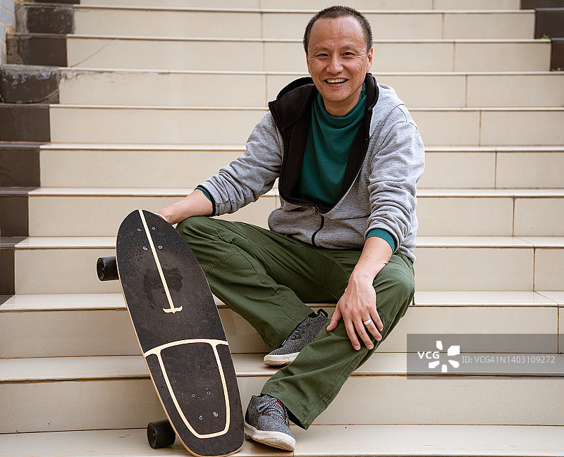 自信的滑板男青年坐在楼梯上图片素材