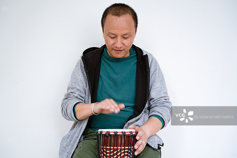 亚洲男子正在演奏非洲鼓图片素材
