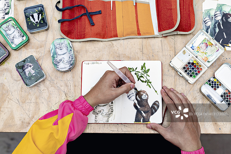 男人在笔记本上用水彩笔绘画图片素材