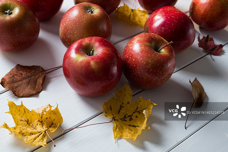 木质背景上的红苹果与秋叶图片素材