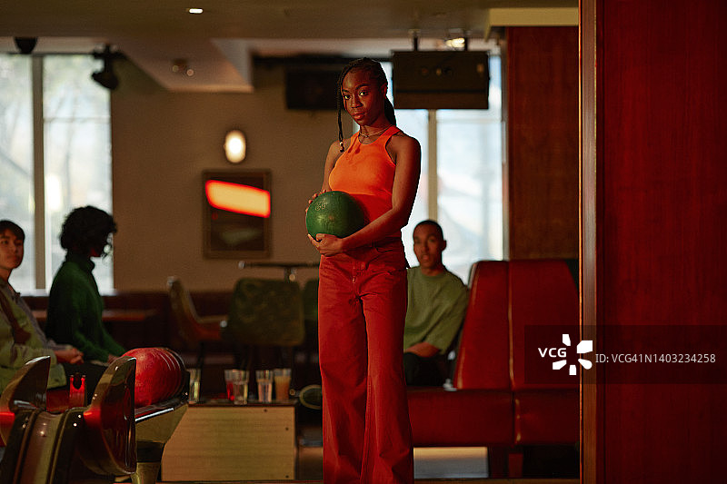 自信的女人在保龄球馆拿着球图片素材