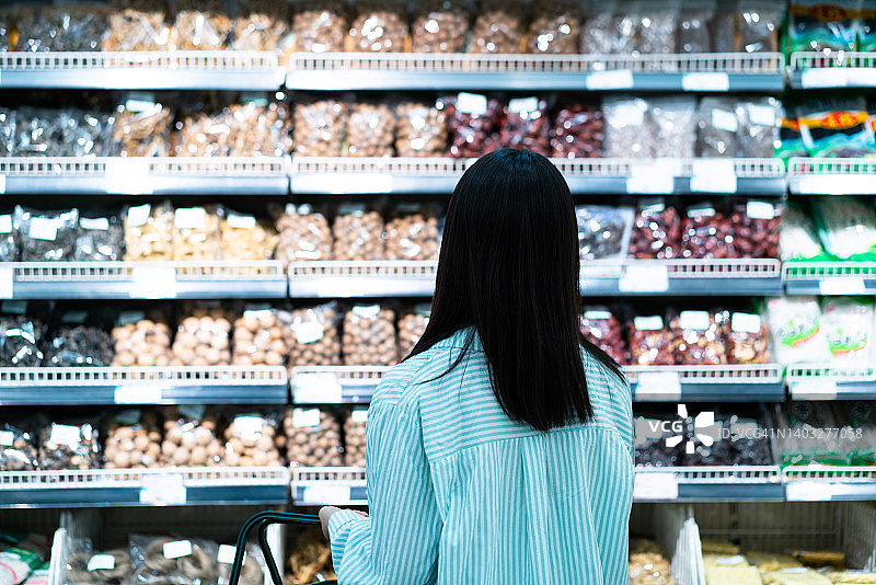 年轻亚裔女性在超市购物图片素材