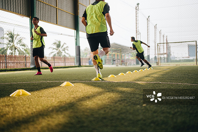 亚洲男人和朋友一起踢足球图片素材