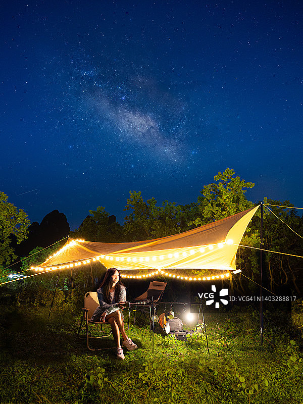 年轻女子在星空下露营图片素材