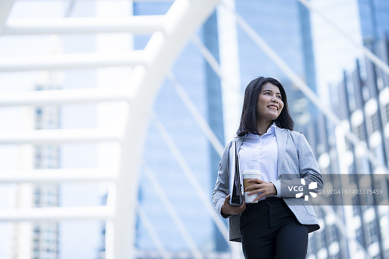 户外快乐的年轻女商人，快乐的工作概念图片素材