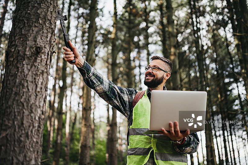 护林员在森林中使用笔记本电脑工作图片素材