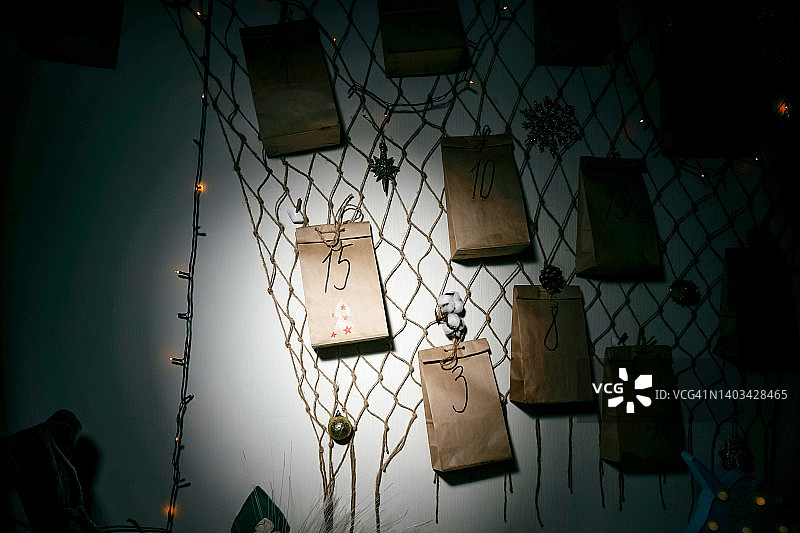 黑暗中墙上由灯笼照亮的自制降临节日历图片素材