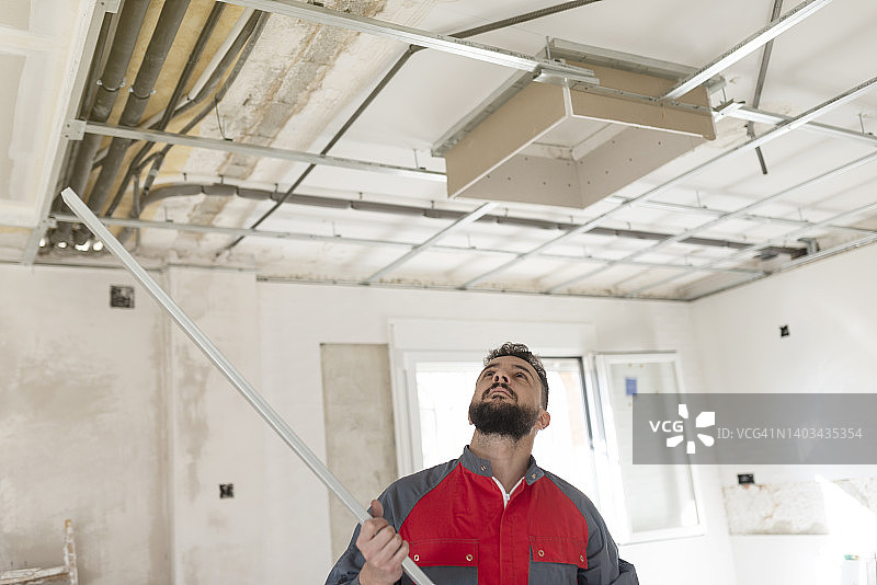 建筑工人安装石膏板天花板和绝缘材料图片素材
