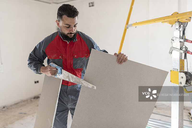 建筑工人安装石膏板天花板和绝缘材料图片素材