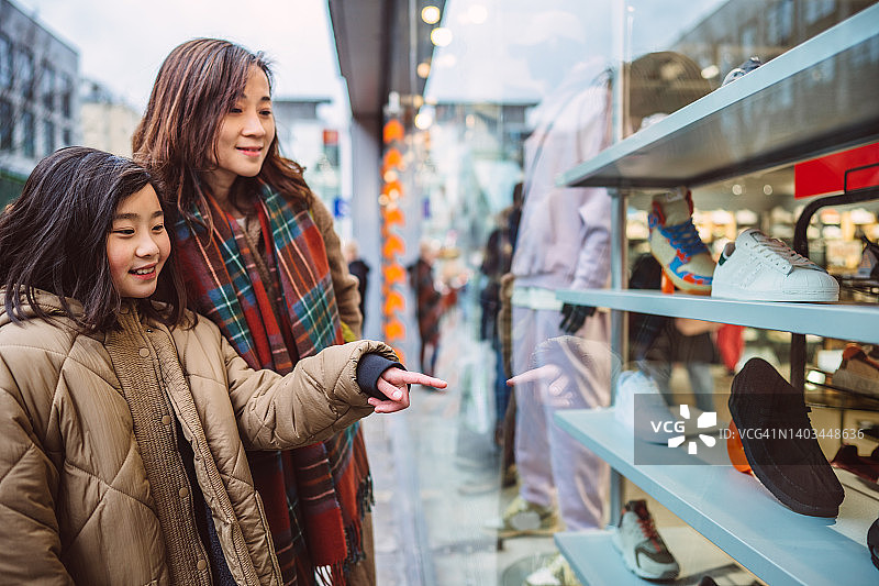 母女在商业街橱窗购物图片素材