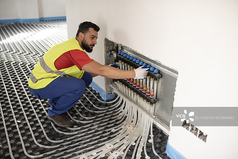 男子安装并检查地暖图片素材