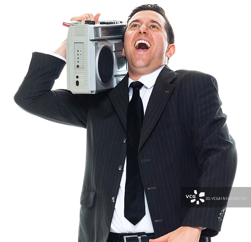 年轻的白人男性经理在白色背景前跳舞，穿着商务装并拿着录音机图片素材