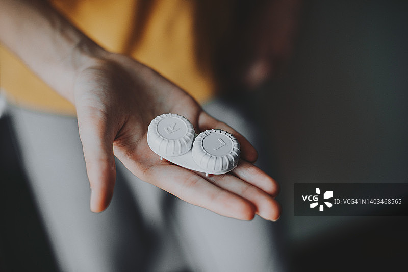 在浴室里手持隐形眼镜盒图片素材